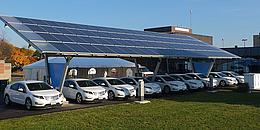 Solarpanele auf Carport, darunter zehn Elektroautos von Chevrolet.