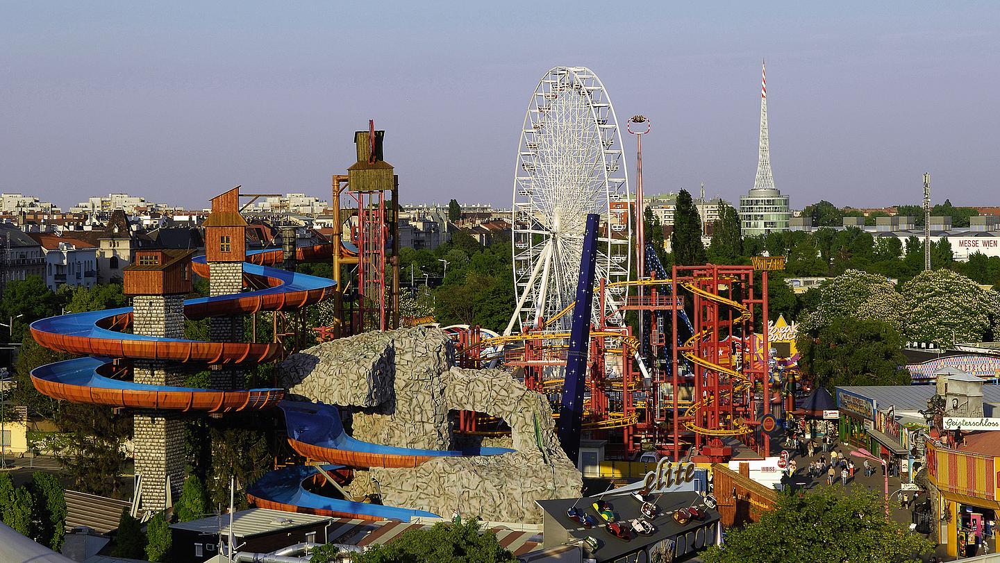 Überblick über den Wiener Prater: im Vordergrund die Wildalpenbahn, im Hintergrund das Riesenrad und andere Attraktionen.