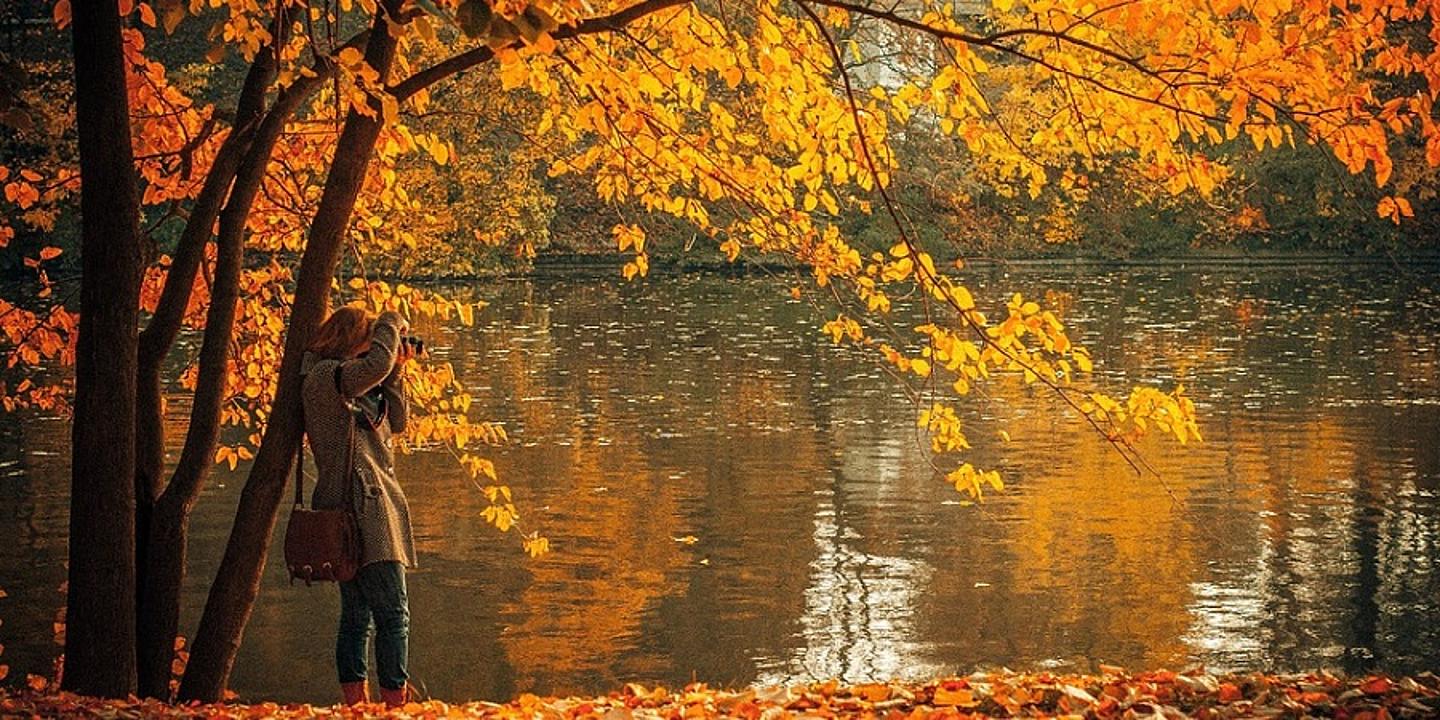 Frau am See in Herbstkulisse