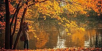 Frau am See in Herbstkulisse