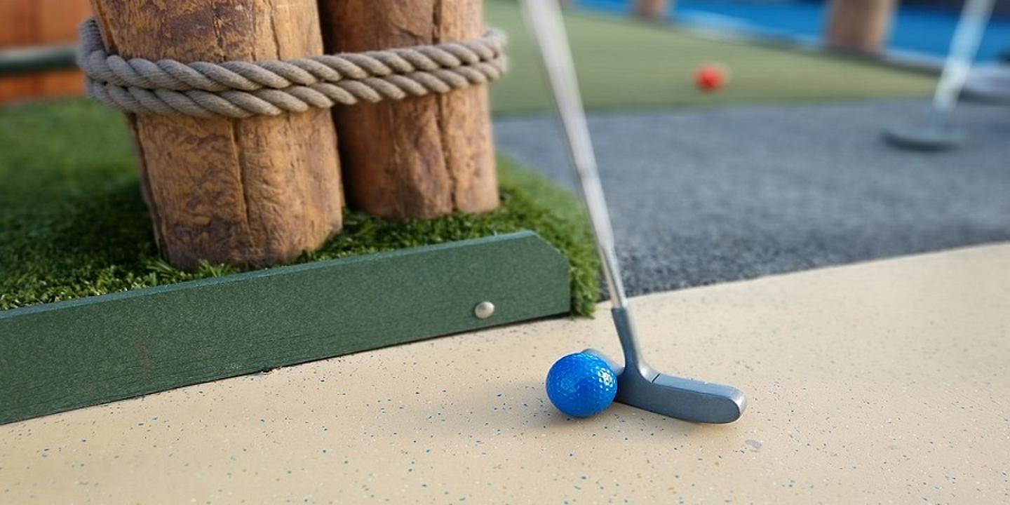 Minigolfschläger mit Ball auf Minigolfplatz