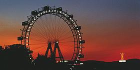 Bild von beleuchtetem Riesenrad bei Nacht.