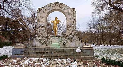 Eine goldene Statue des Komponisten Johann Strauß steht auf einer schneebedeckten Wiese