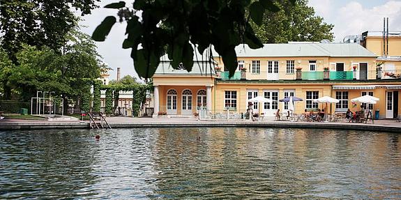 Ein kleiner Fluss fließt gemütlich vor dem schönen Eingangsgebäude zum Thermalbald