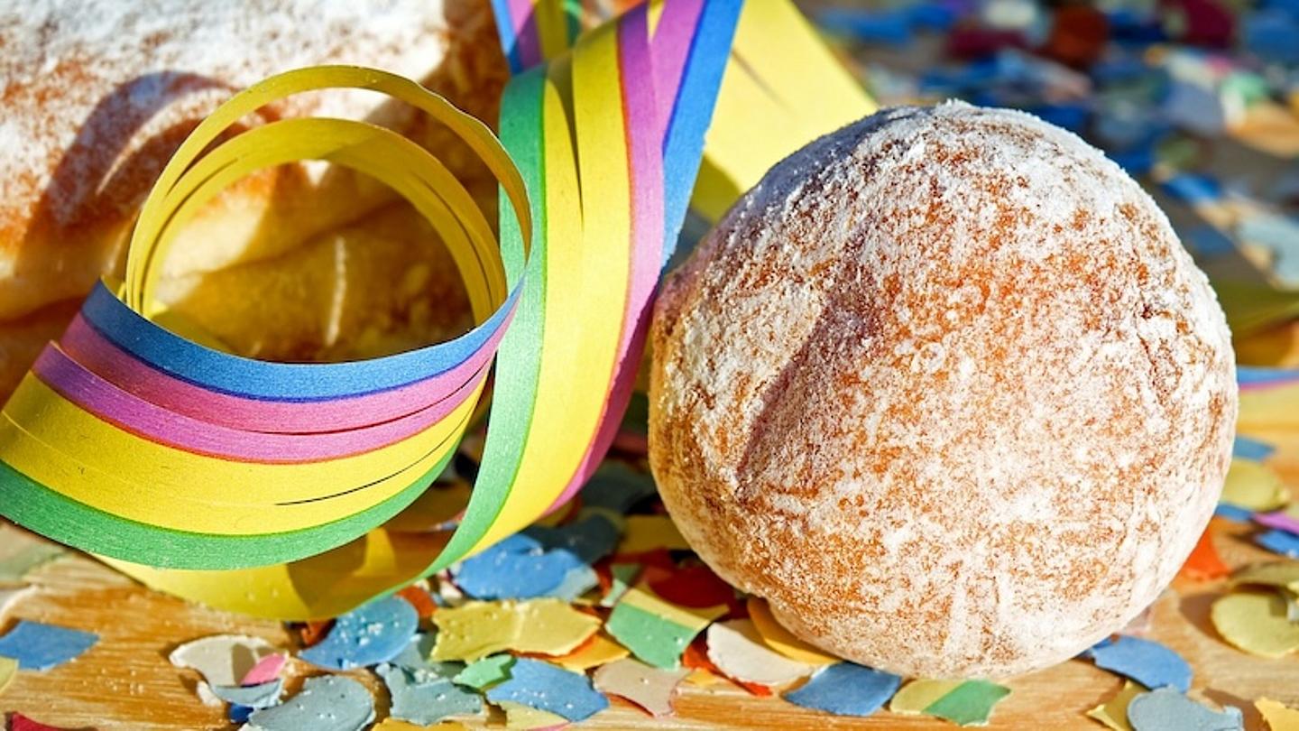 Krapfen auf dem Tisch mit Konfetti und Luftschlangen