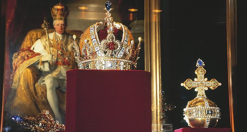 Reichskleinodien, Krone, Reichsapfel und Zepter von Kaiser Rudolf II mit Porträt im Hintergrund in der Schatzkammer Wien.