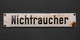 Altes Nichtraucher-Schild vor grauem Hintergrund