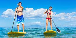 zwei Stand up Paddler am Wasser mit Paddel und Board