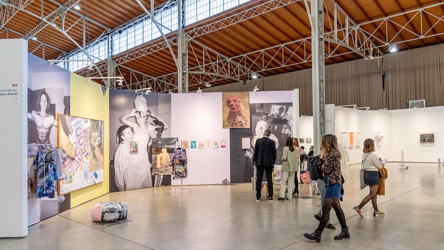 Besucherinnen und Besucher vor Leinwänden mit Kunst in der Marx Halle