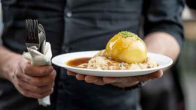 Kellner, der Original Waldviertler Erdäpfelknödel serviert