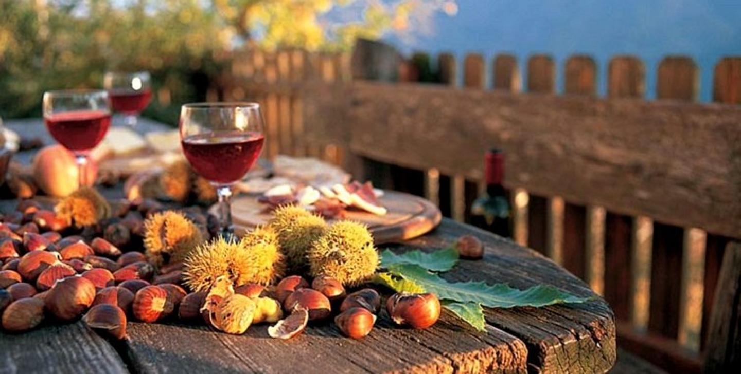 Kastanien und roter Wein auf einem Holztisch 