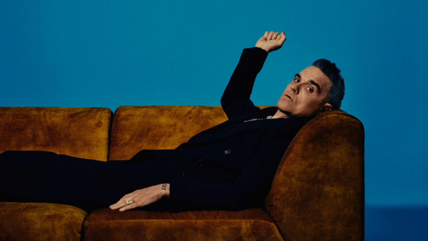 Der britische Pop Superstar Robbie Williams liegt auf einer Couch