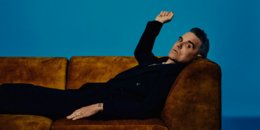 Der britische Pop Superstar Robbie Williams liegt auf einer Couch