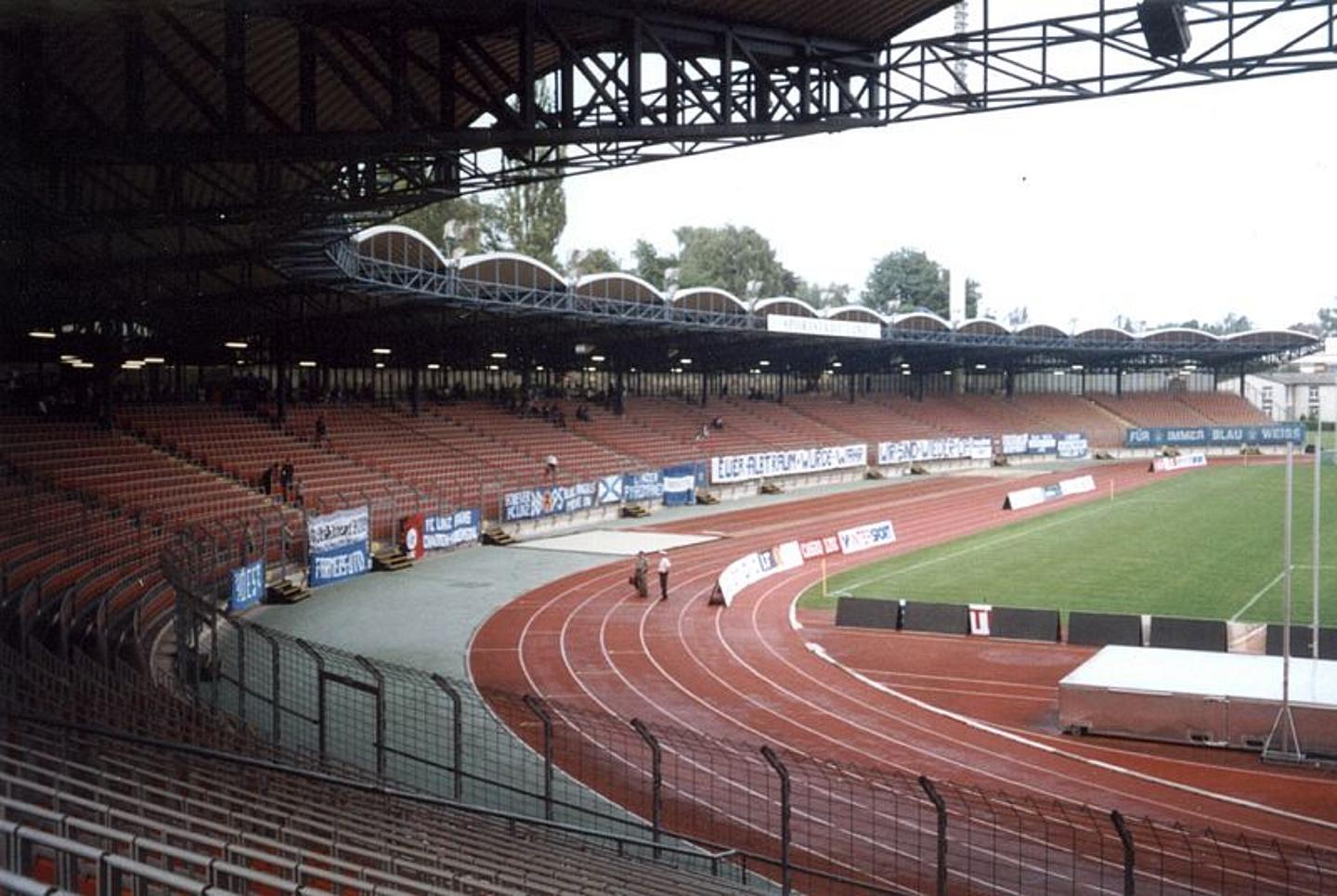 Das Linzer Gugl Stadion mit Blick auf Tribüne und Laufbahn rund um das Fußballfeld.