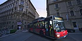 Bus der Wiener Linien schlängelt sich in der Dämmerung durch die Straßen.