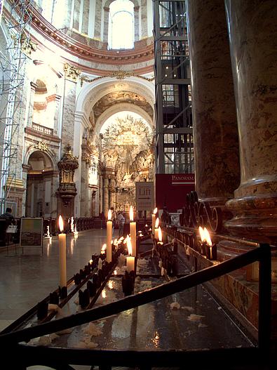 Innenansicht der Karlskirche - im Vordergrund stehen brennende Kerzen.