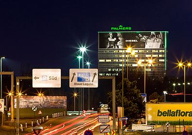 Großflächenwerbung auf Fassade Hochhaus bei Nacht