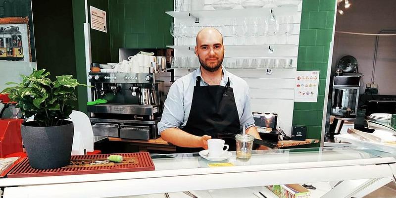 Daniel Pereira Ferreira Machado, der Inhaber des Austrogalo, steht hinter der Theke und hat gerade einen Kaffee zubereitet