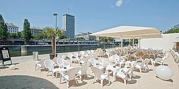 Strandterasse mit vielen Stühlen und Sonnenschirmen an einem schönen Tag am Donaukanal