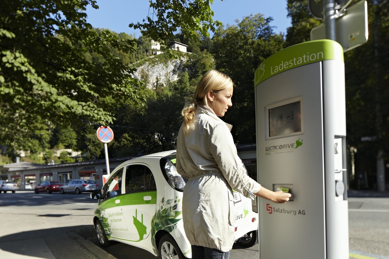 Frau schaltet mit RFID-Karte die Ladesäule der Salzburg AG frei.