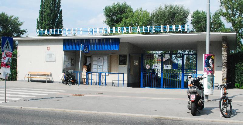 Das Kassahäuschen mit Überschrift Städtisches Strandbad Alte Donau, ein Fahrrad, ein Motorrad und eine Bank stehen davor