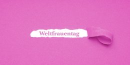 rosa Hintergrund aus Krepppapier darunter das Wort Weltfrauentag