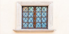 Fenstergitter vor Fenster an gelber Wand