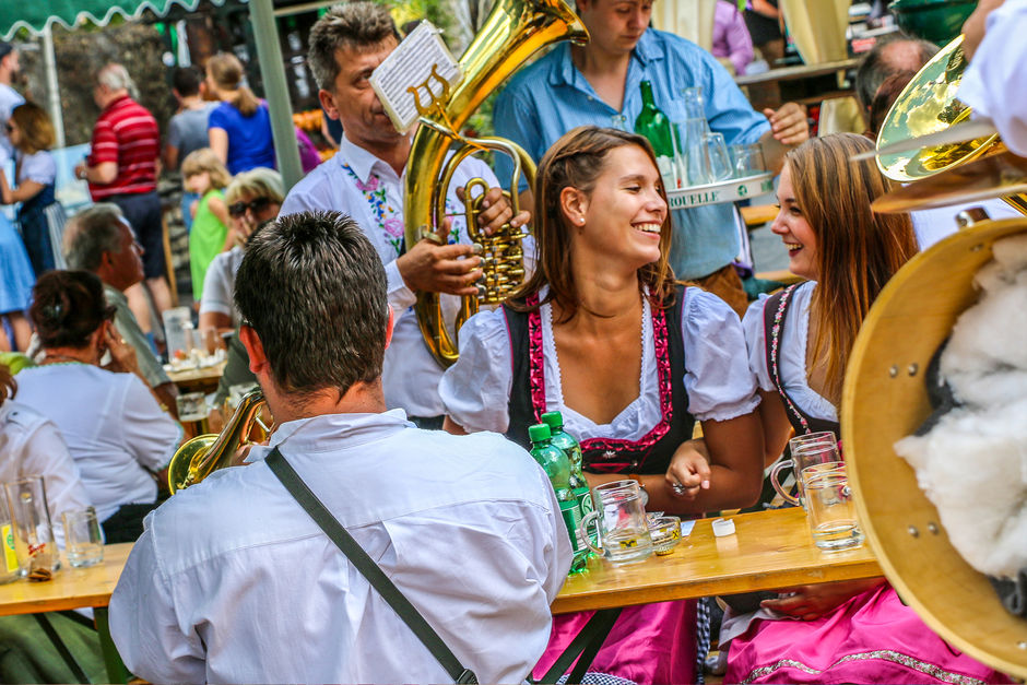 Zwei junge Frauen im Dirndl, Publikum am Neustifter Kirtag, im Hintergrund Blasmusik