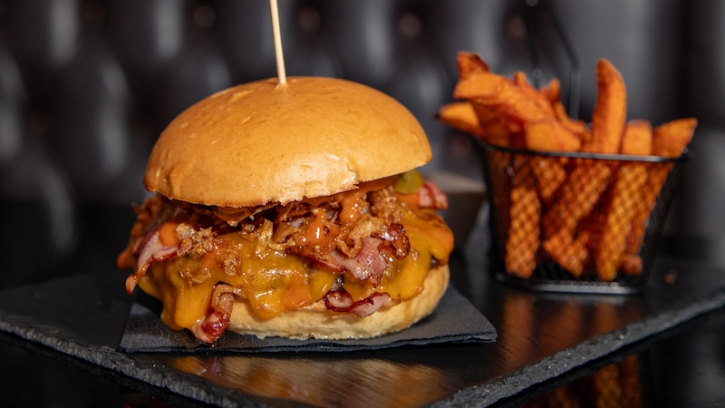 Deftiger Burger mit Bacon, dazu Süßkartoffelpommes