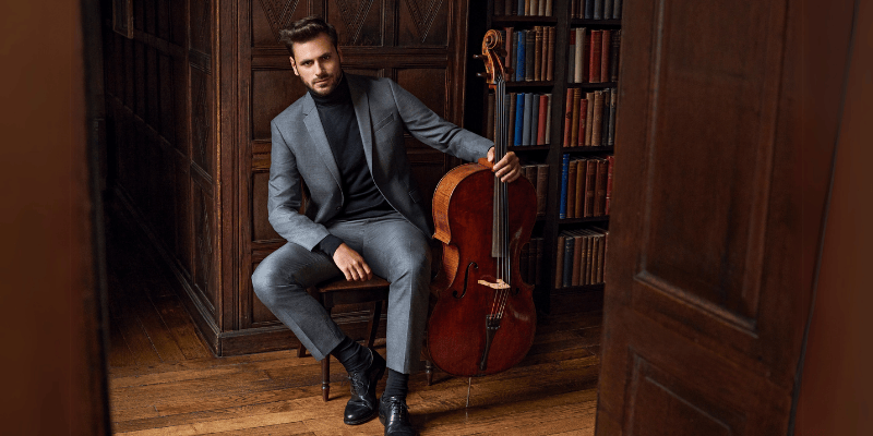 Der Cello Musiker Stjepan Hauser sitzt mit seinem Cello in einer Bibliothek