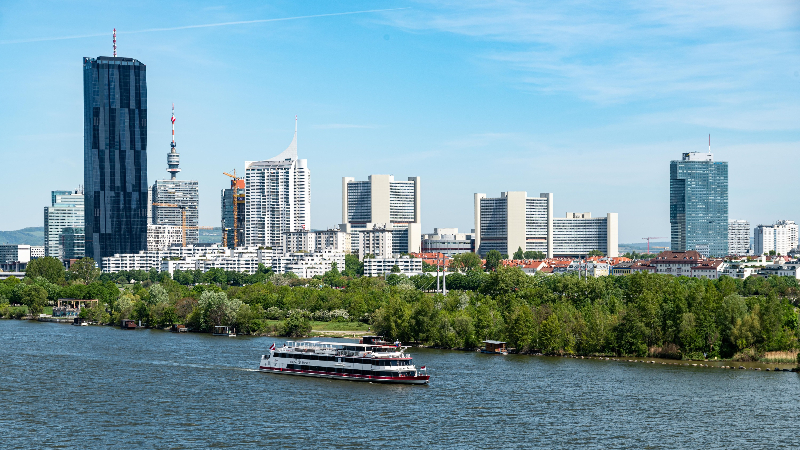 Schiff fährt vor der Skyline Wiens