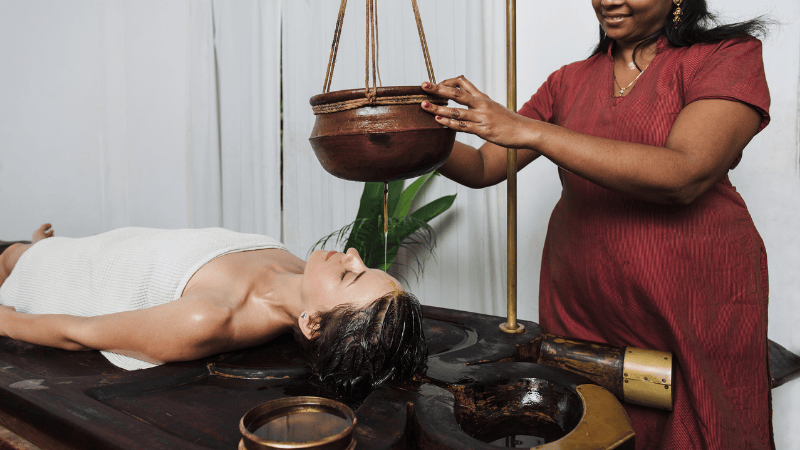 Eine Frau bekommt eine traditionelle Ayurveda Massage von einer Masseurin