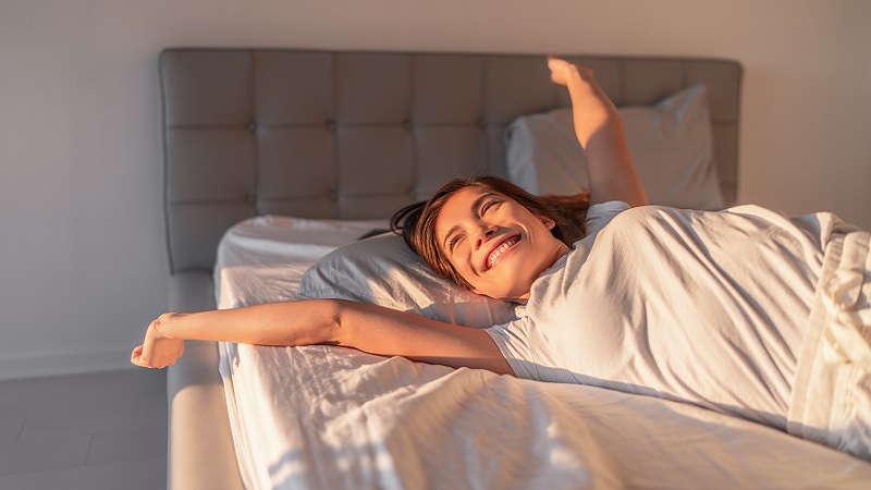 Frau hat super geschlafen und streckt sich genüßlich in der Morgensonne